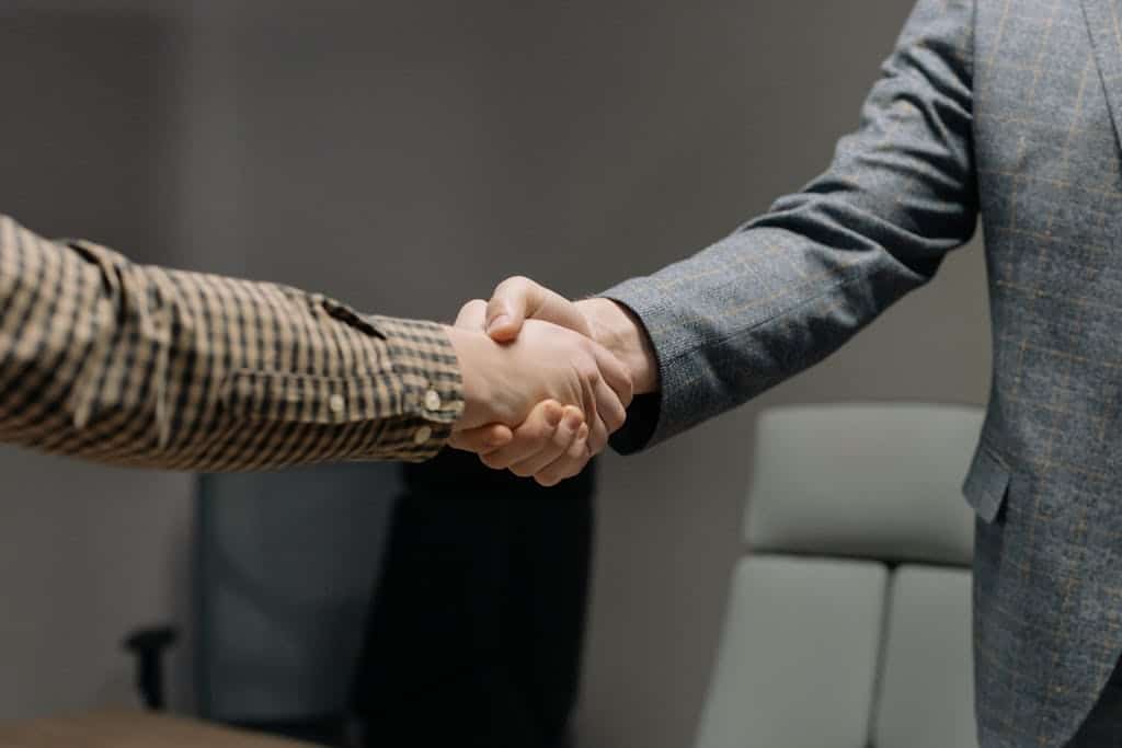 Close-up of two professionals shaking hands in an office, symbolising trust and profesionalism