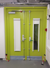 Store à enrouleur à blocage laser actionné par chaîne couvrant les fenêtres sur les portes d'une université de Londres