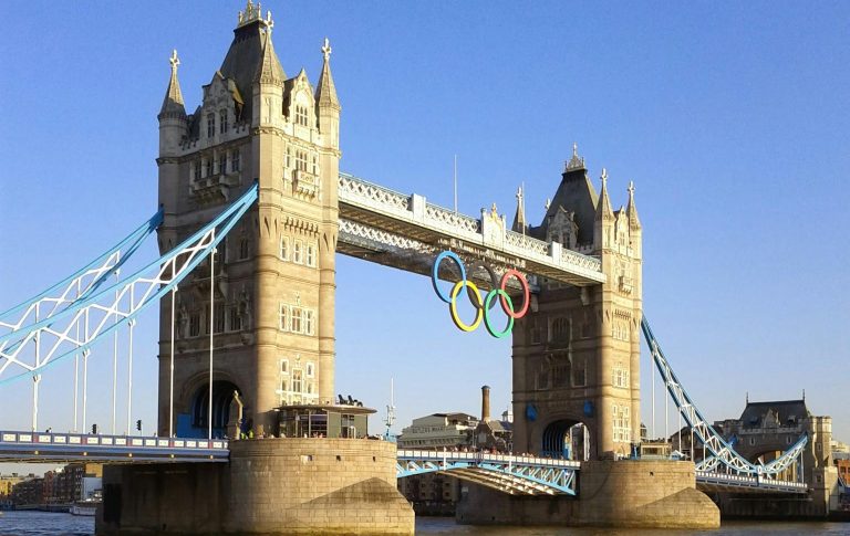 View of Tower Bridge in London showcasing the Olympic Rings in daylight over the River Thames.